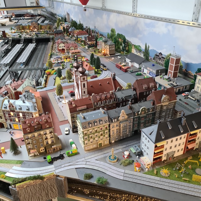 Blick auf die detailreich gestaltete Modellstadt mit Bahnhof, Häusern und Gleisanlagen der stationären H0-Vereinsanlage.