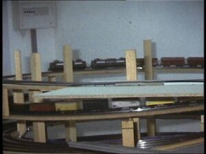 Ein Modellzug fährt durch den mehrstöckigen Gleiswendel im Rohbau. Die Gleistrassen werden von senkrechten Holzstützen getragen.
