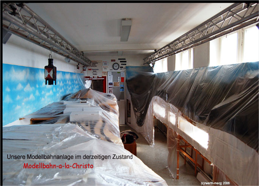 Blick in den MEC-Clubraum am 12. April 2006. Während der Umbauarbeiten sind große Teile der Modellbahnanlage mit durchsichtiger Schutzfolie abgedeckt. Auf dem Foto steht der humorvolle Schriftzug „Modellbahn-a-la-Christo“.