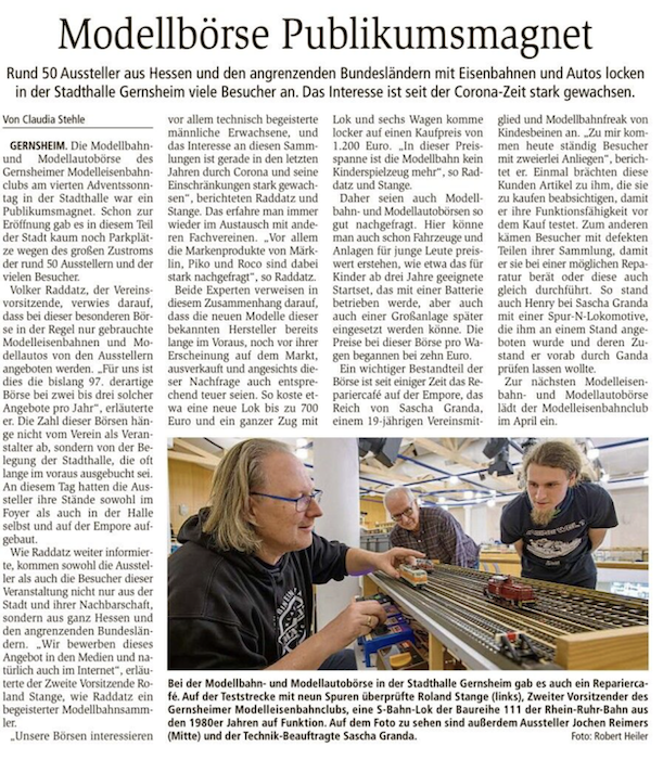 Zeitungsartikel aus dem Groß-Gerauer Echo vom 23. Dezember 2025 mit der Überschrift „Modellbörse Publikumsmagnet“. Der Bericht zeigt ein Foto von drei Modellbahnfreunden an einer Teststrecke mit mehreren Lokomotiven.
