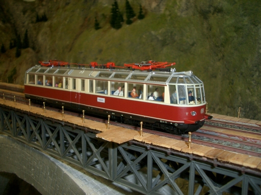 Rot-beiger Aussichtstriebwagen ET 91 mit großen Panoramafenstern auf der Modellbahnbrücke