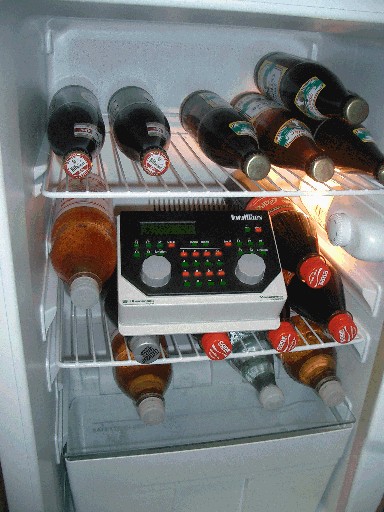 Modellbahn-Digitalzentrale IntelliBox steht zwischen Getränkeflaschen in einem geöffneten Kühlschrank
