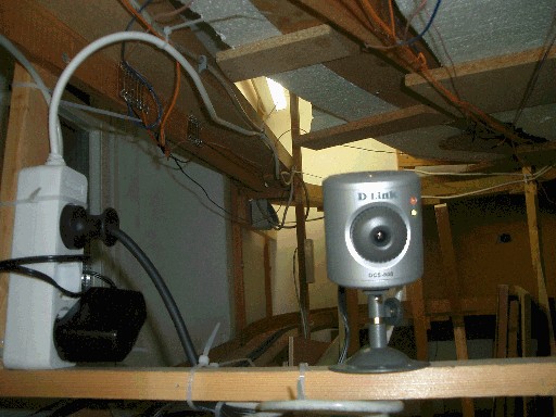 Silberne IP-Kamera von D-Link auf einer Holzleiste unterhalb der Modellbahnanlage montiert
