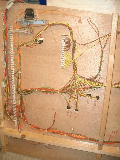 Unterseite eines Bahnhofsmoduls mit geordnet verlegten, mehrfarbigen Kabelbündeln, Anschlussleisten und elektrischen Bauteilen.