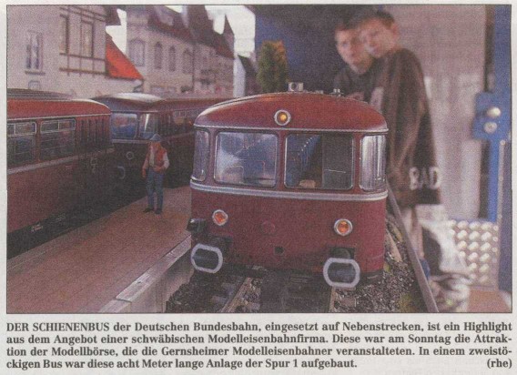 Historischer Zeitungsausschnitt mit einem Foto eines roten Schienenbusses der Deutschen Bundesbahn auf einer Spur-1-Modellbahnanlage.