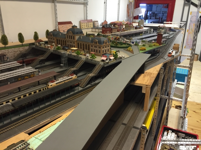 Noch im Bau befindliche Straßenrampe zum Bahnhofsvorplatz von Schöfferstadt. Sie führt über mehrere Bahngleise hinauf zur Stadtebene mit dem Bahnhofsgebäude.