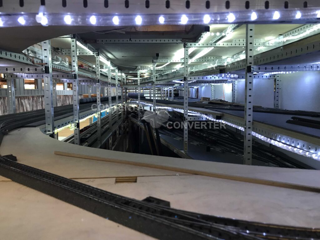 Blick in den Untergrund der MEC-Modellbahnanlage mit mehreren übereinanderliegenden Gleisebenen, Metallstützen und LED-Beleuchtung.