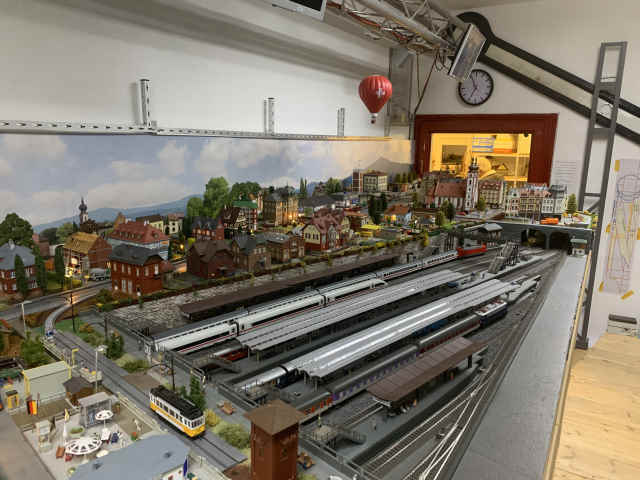 Gesamtansicht der mehrstöckigen Modellbahnanlage des MEC Gernsheim mit dem Bahnhof Schöfferstadt Hbf, zahlreichen Gleisen und Zügen sowie der darüberliegenden, detailreich gestalteten Modellstadt.