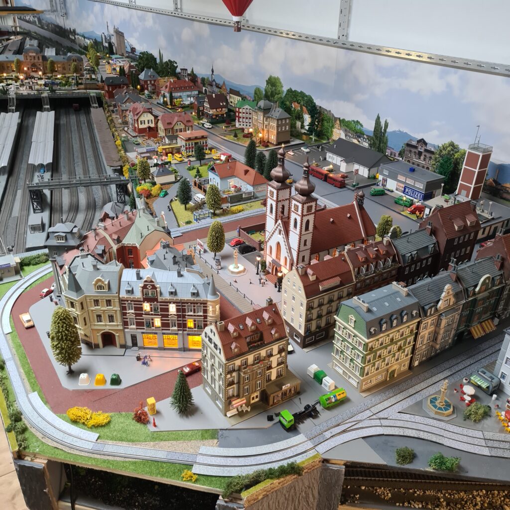 Gesamtansicht der Modellbahnstadt Schöfferstadt mit dicht bebauten Straßenzügen, Kirche und Bahnhofsgleisen.