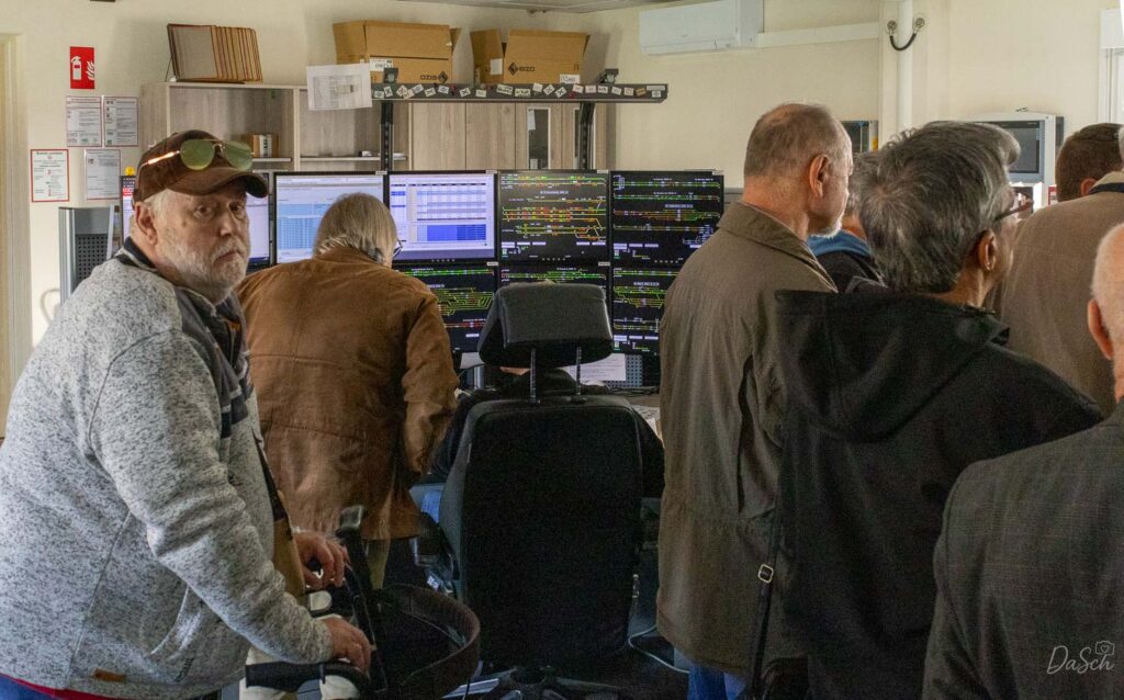 Mehrere Teilnehmer des BDEF-Regionaltreffens betrachten die Monitorarbeitsplätze im Stellwerk der Riedbahn.