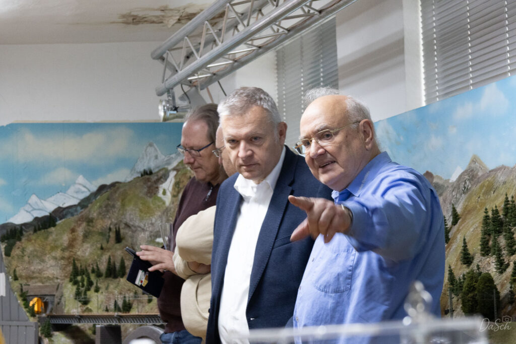 MEC-Vorsitzender Volker Raddatz zeigt Bürgermeister Peter Burger während der Einweihung einen Bereich der Modellbahnanlage.