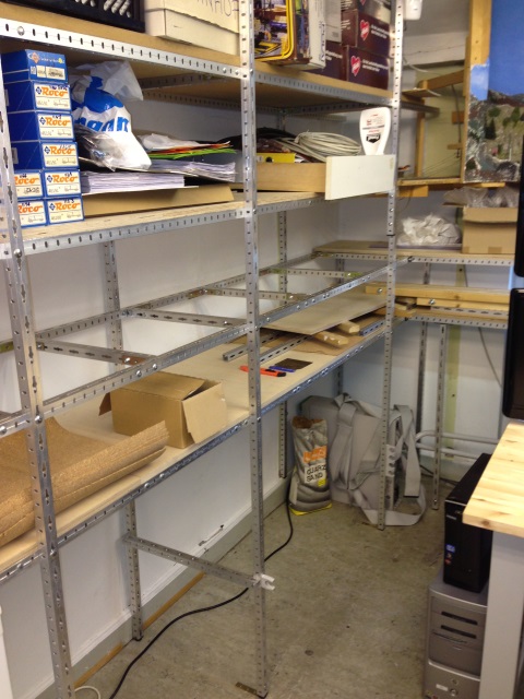 Metallregale mit Baumaterial, Kartons und Zubehör für den Aufbau der Modellbahnanlage