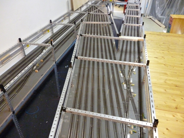 Metallrahmen der Modellbahnanlage mit teilweise verlegten Gleisen