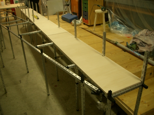 Langer Anlagenunterbau mit heller Holzplatte und sichtbaren Metallstützen