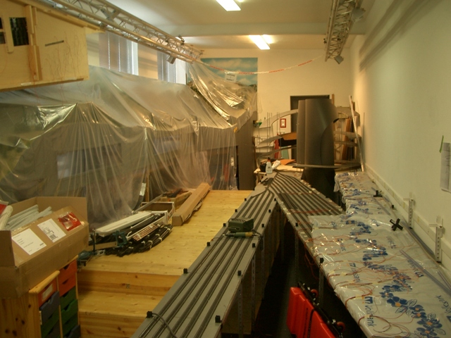 Langer Vereinsraum mit abgedeckter Modellbahnanlage und neu verlegten Gleisen auf der gegenüberliegenden Seite