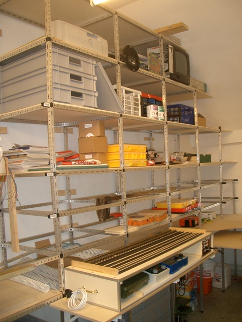 Hohe Metallregale mit Kunststoffboxen, Werkzeugen und Modellbahnmaterial