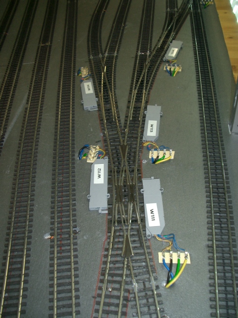 Mehrgleisiger Modellbahnhof mit zahlreichen Weichen und beschrifteten Weichenantrieben