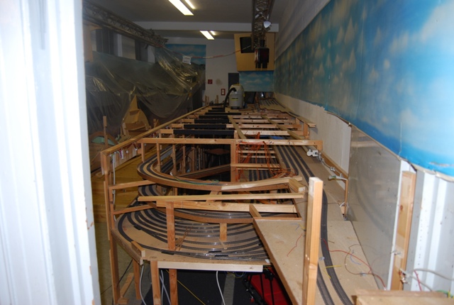 Gesamtansicht der zurückgebauten Modellbahnanlage mit offenen Holzrahmen und mehreren verbliebenen Gleisebenen.